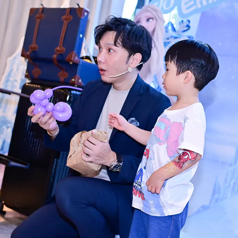 Magic Ka 向小朋友展示紫色扭氣球小狗