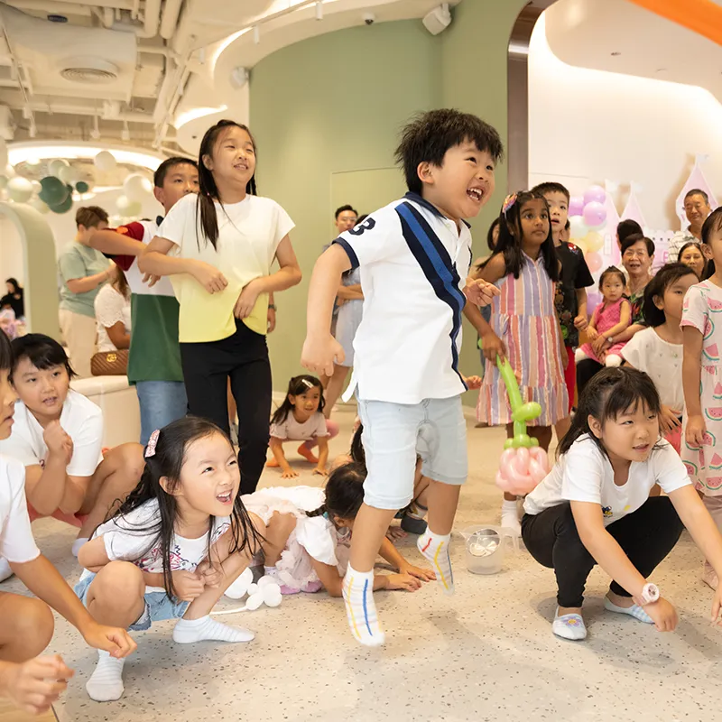 小朋友在派對遊戲中興奮地跳起,笑容滿面