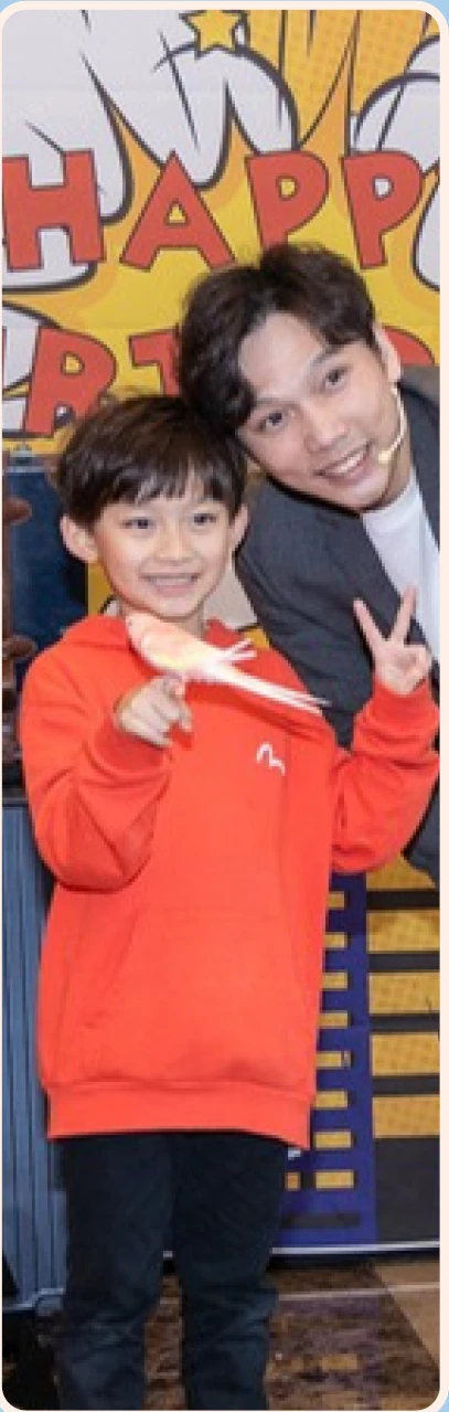 Magic Ka with a birthday child holding a cockatiel